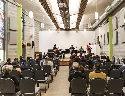 Contemporary students play on stage in Wood Hall with an audience