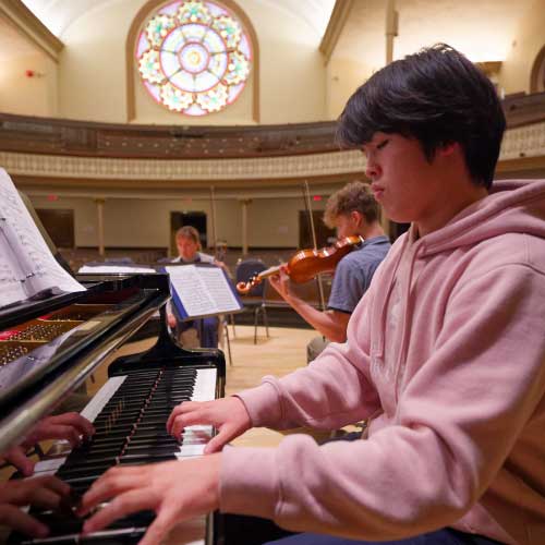 Collegium students practice piano and violin on AGPH stage