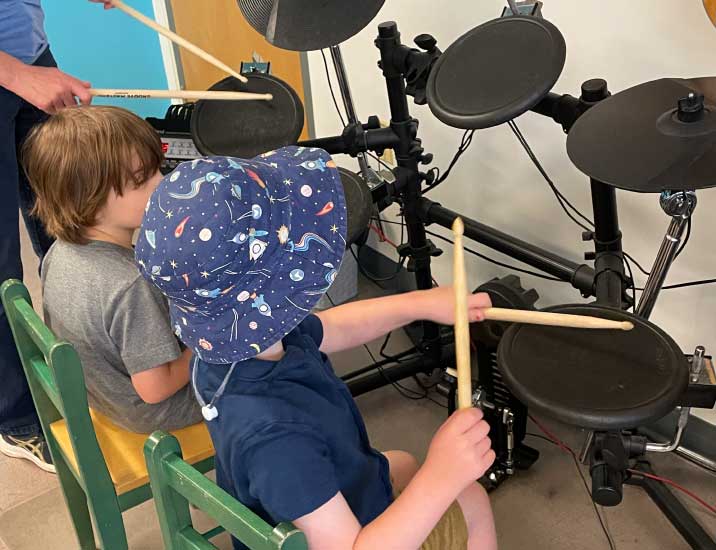 Music Therapy clients play an electric drum machine