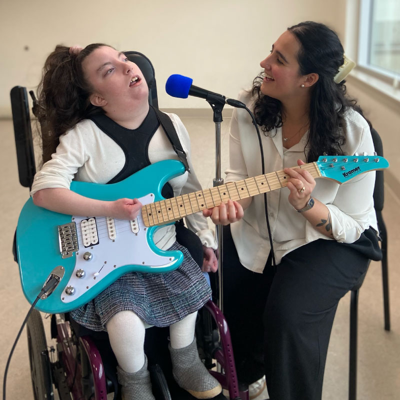 Noa Kay in Music Therapy session with a client playing a blue guitar